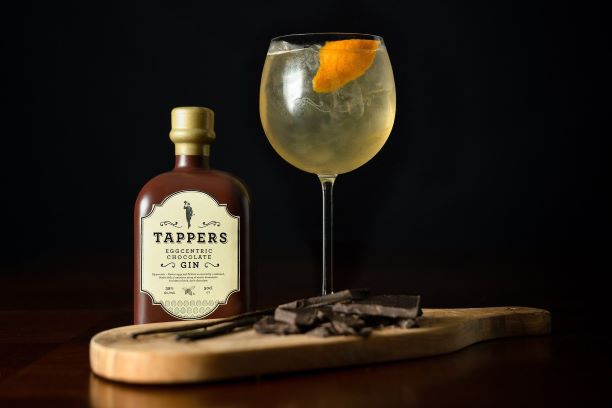 a bottle of tappers eggcentric chocolate gin on a bar with a gin and tonic 