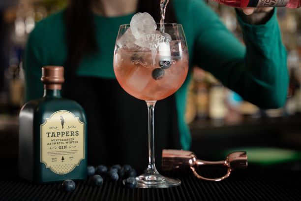 a bottle of Wintergreen Aromatic Winter Gin in a bar with agin and tonic 