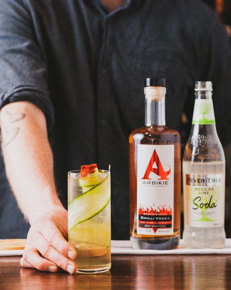 a bottle of chilli vodka with a cocktail being served 