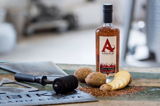 a bottle of chilli vodka with sliced potato and chilli spice