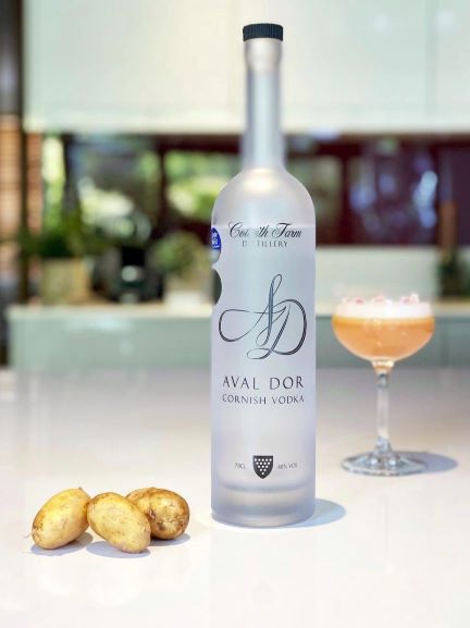 a bottle of colwith farm aval dor vodka with a cocktail in the background
