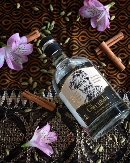 a bottle of gin wala on a sari with flowers and spices