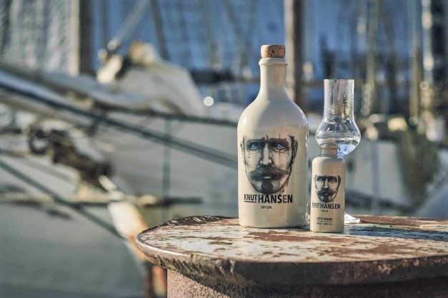 A BOTTLE OF GIN IN A CERAMIC BOTTLE IN A DOCKLAND SETTING