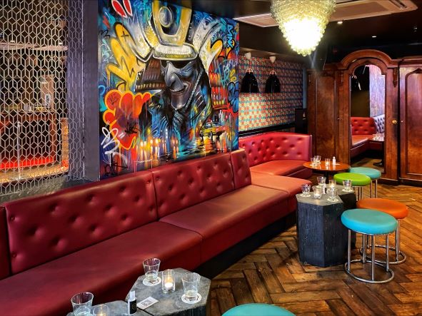 an eclectic bar with a riot of colour with low slung chairs and tables