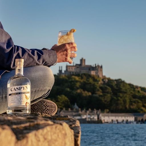 a man sitting drinking a gin and tonic with a castle in the background