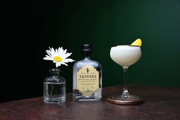 a bottle of brightside gin with a cocktail on a wooden table 
