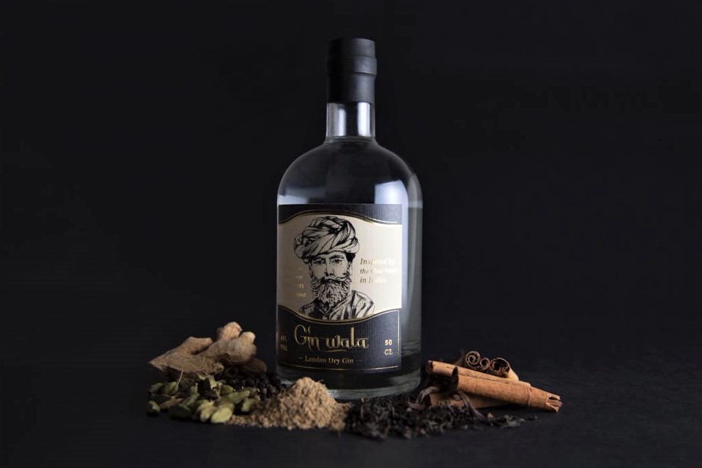 a bottle of gin wala with a selection of spices