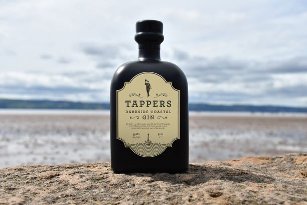 A BOTTLE OF DARKSIDE ON A SANDY BEACH