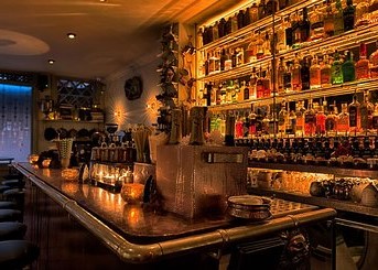 a fully stocked back bar with spirits and cocktail barware